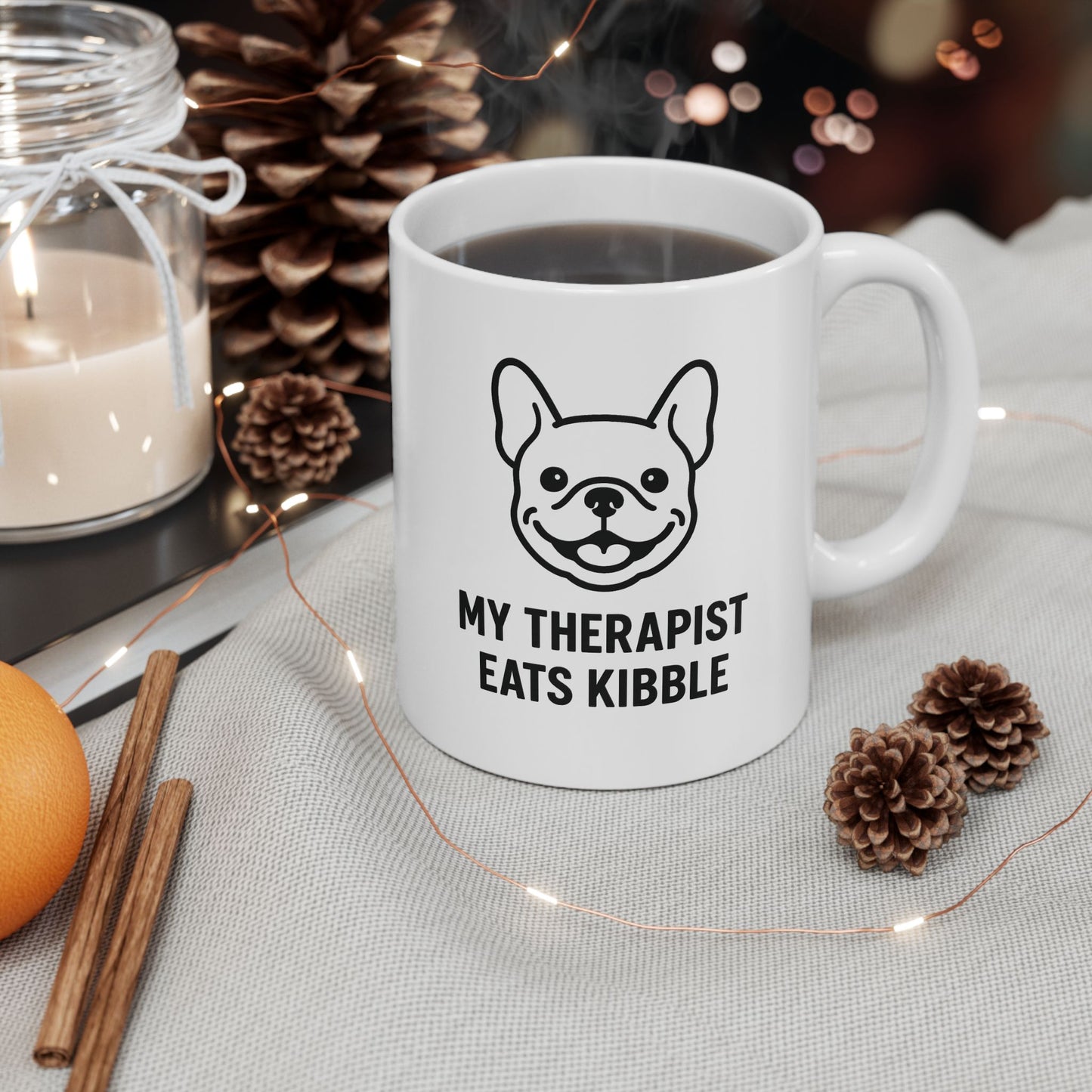 White mug with a dog illustration and text on a table with decorative items