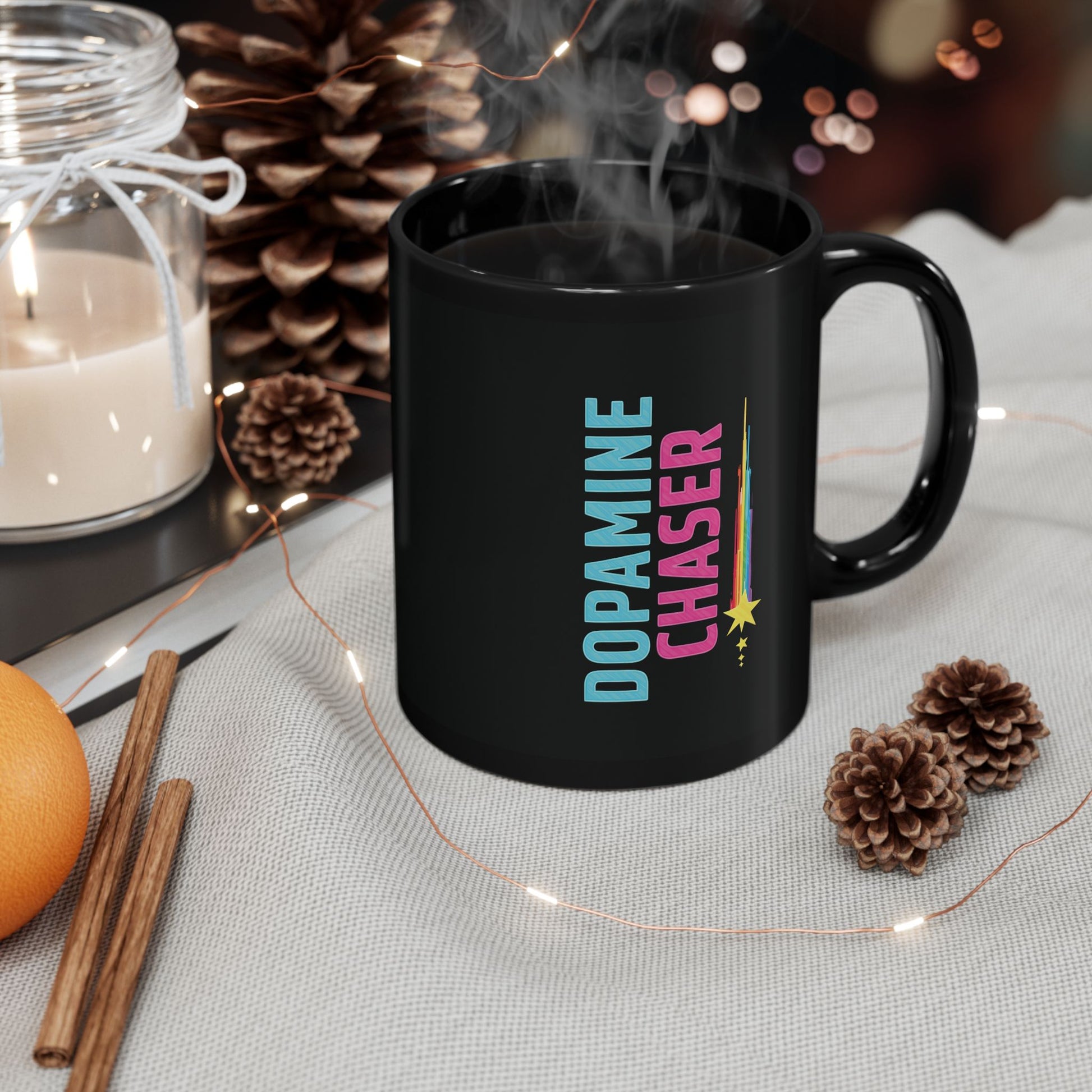 Black mug with 'Dopamine Chaser' text on a table with decorative items