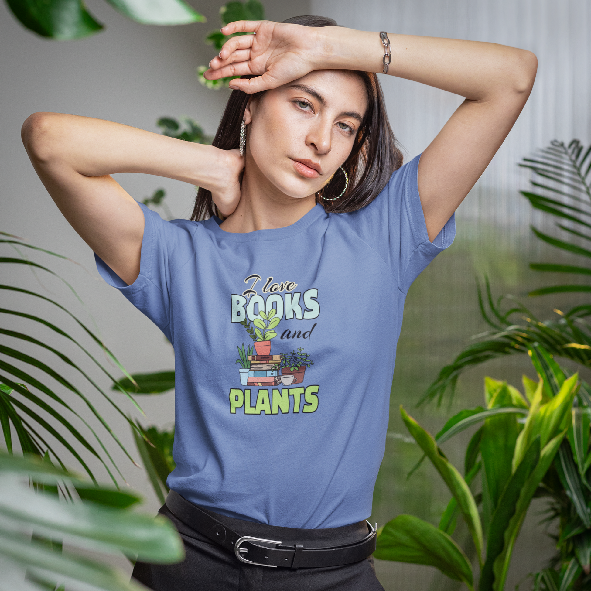 Woman wearing a blue t-shirt with 'I love books and plants' design, surrounded by plants.