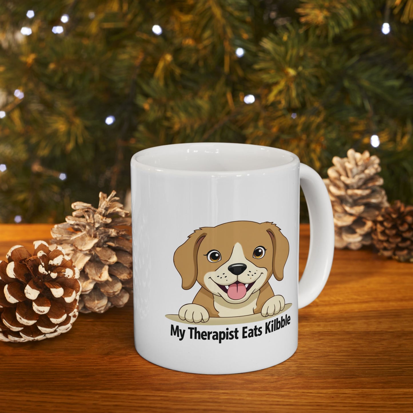 White mug with a dog illustration and text in front of a Christmas tree.