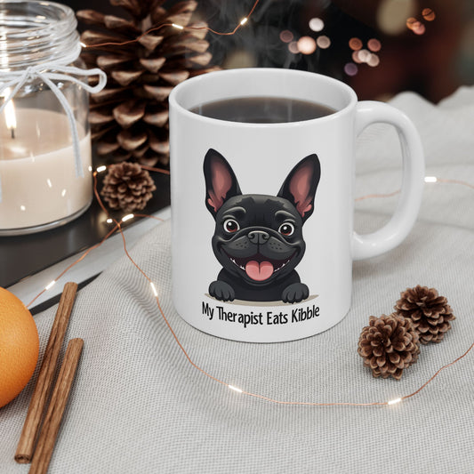 White mug with a black dog illustration and text, surrounded by decorative items on a table.